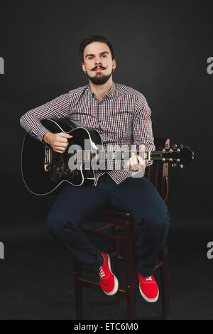 handsome guy with beard holding acoustic guitar Stock Photo