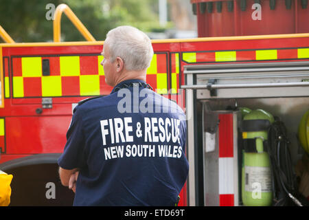 Fire and Rescue New South Wales, male Fire brigade officer in uniform stood beside Fire engine,Sydney,Australia Stock Photo