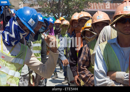 Construction workers take part in stretching exercises to enhance safety at a construction site in Phnom Penh, Cambodia. Stock Photo