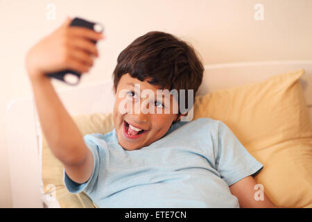Young boy making selfie pictures with smart phone - with shallow depth of field Stock Photo