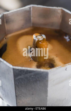 Italian traditional coffeemaker with hot coffee flowing out from the spout Stock Photo