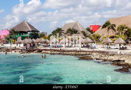 Vacationing passengers from a luxury cruise ship enjoy a beautiful day swimming and relaxing at a Cozumel, Mexico beach. Stock Photo