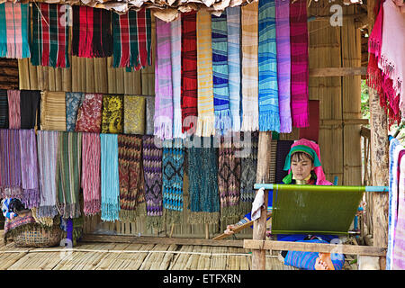 A woman weaving on the porch of her hut at the hill tribes village near Chiang Rai. Stock Photo