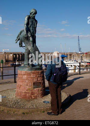 Man looking at statue of the Ancient Mariner, Watchet Harbour, Somerset, UK Stock Photo