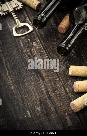 Bottles of wine, corks and corkscrew on wooden background. Toned image Stock Photo