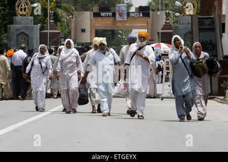 Lahore. 13th June, 2015. Indian Sikh pilgrims cross the Wagha border post in eastern Pakistan's Lahore on June 13, 2015. Hundreds of Sikh pilgrims arrived in Pakistan on Saturday to attend ceremonies marking the death of the fifth Sikh Guru, Arjan Dev Ji. © Jamil Ahmed/Xinhua/Alamy Live News Stock Photo