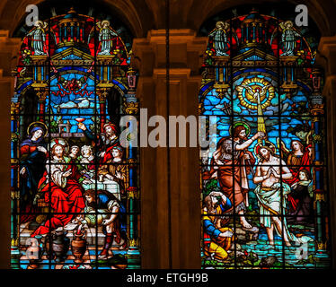 Stained glass window depicting, on the left, Jesus at the Wedding at Cana, and, on the right, Jesus baptized in the River Jordan Stock Photo