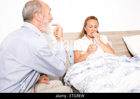 Giving medication to an elderly woman Stock Photo