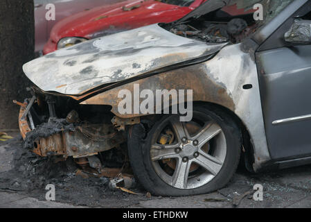 side of a burnt out car in an outdoor park Stock Photo