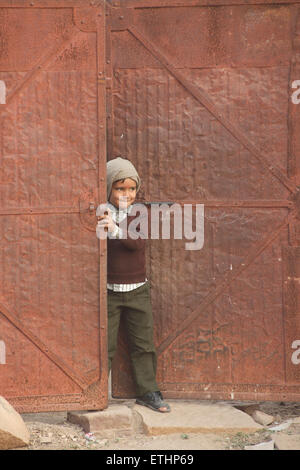 Indian boy with hole in shoe at doorway. Jodhpur, Rajasthan, India Stock Photo