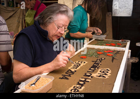 UK, England, Derbyshire, Eyam, volunteer constructing the Requisitioning of Horses 2014 well dressing Stock Photo