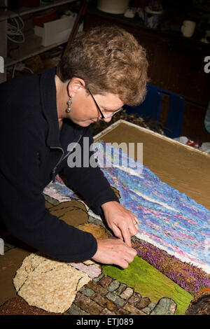 UK, England, Derbyshire, Eyam, volunteer constructing the Requisitioning of Horses 2014 well dressing Stock Photo