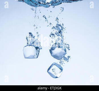 Falling ice cubes in water splashes Stock Photo