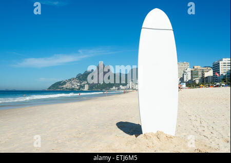 Stand up paddle long board surfboard stuck in the sand on Ipanema Beach Rio de Janeiro Stock Photo