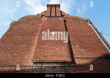 A brick gable end of a house with chimney against blue sky in Canterbury, Kent, UK. Stock Photo