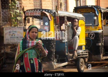 Indian woman in colourful sari and auto rickshaws. Jodhpur, Rajasthan, India Stock Photo