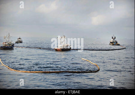 Clean up crews use fire boom to gather surface oil before conducting controlled burns following the BP Deepwater Horizon oil spill disaster as efforts to contain and clean the millions of gallons of crew continue May 6, 2010 in the Gulf of Mexico. Stock Photo