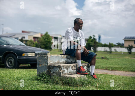 (150614) -- NEW ORLEANS, June 14, 2015 (Xinhua) -- Robert Green, a Lower Ninth Ward resident and Hurricane Katrina survivor, sits on the steps that once led into his mother's Lower Ninth Ward home in New Orleans, in Lower Ninth Ward, New Orleans, June 12, 2015. Green lost his mother and granddaughter in 2005's devastating hurricane Katrina. Ten years after Hurricane Katrina brought New Orleans to its knees and left an emotional footprint across the United States as people witnessed how the U.S. government failed to respond promptly, a predominantly African-American community of the city still Stock Photo