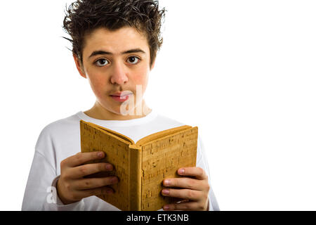 A handsome Hispanic boy reads with serene eyes a brown blank book made with cork Stock Photo