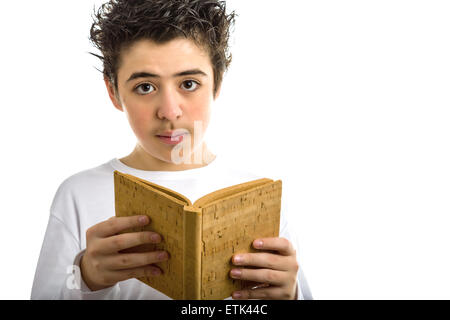 A handsome Hispanic boy reads with serene eyes a brown blank book made with cork Stock Photo