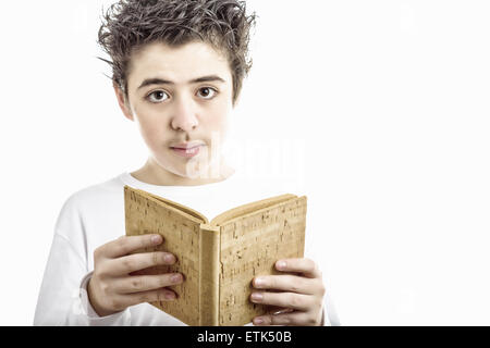 A handsome Hispanic boy reads with serene eyes a brown blank book made with cork Stock Photo