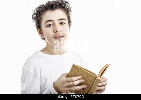 A handsome Hispanic boy reads with serene eyes a brown blank book made with cork Stock Photo