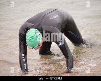 Portsmouth, England 14th June 2014.A competitor crawls from the sea, exhausted, during the Portsmouth Try a Tri triathlon event. The event consisted of a number of sprint triathlons of different lengths to accommodate differing abilities. Credit:  simon evans/Alamy Live News Stock Photo