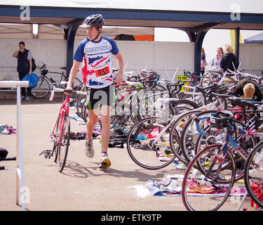 Portsmouth, UK. 14th June, 2015. A young Athlete leaves the transition area with his bike after completing a 750M swim in the solent during  the Portsmouth Try a Tri triathlon. The event consisted of a number of sprint triathlons of different lengths to accomodate differing abilities. Credit:  simon evans/Alamy Live News Stock Photo
