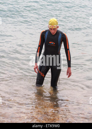 Portsmouth, UK. 14th June, 2015. A competitor in the Portsmouth Try a Tri triathlon stands motionless and exhausted after completing a 750M swim in the solent. The event consisted of a number of sprint triathlons of different lengths to accomodate differing abilities. For many taking part this was their first Triathlon. Credit:  simon evans/Alamy Live News Stock Photo