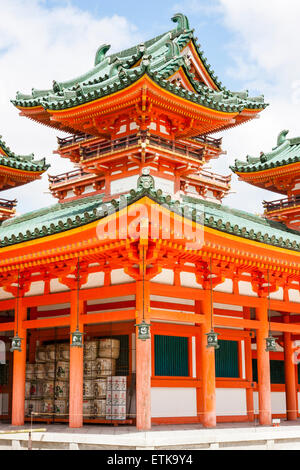 The Byakko-ro, white Tiger tower, of the Heian Shrine in Kyoto. Vermilion building with three towers in the Chinese-style with green roofs. Blue sky. Stock Photo