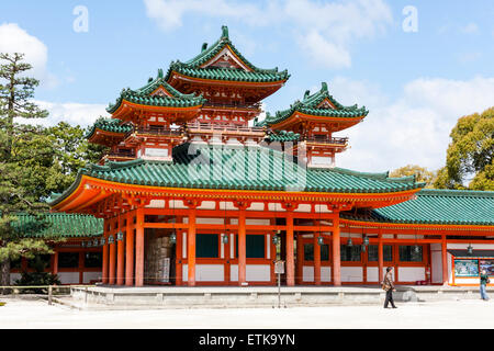 The Byakko-ro, white Tiger tower, of the Heian Shrine in Kyoto. Vermilion building with three towers in the Chinese-style with green roofs. Blue sky. Stock Photo