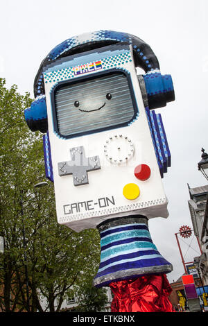 Manchester, UK 14th June, 2014.  'Cyber mascot Pixel – a Gameboy-shaped' Robot  Manchester Day was created in 2010 and has now become one of the North West’s flagship events of the summer. The purpose of the event is to celebrate the creativity and diversity of the city. Over 2,500 performers and artists from local communities bring streets and squares to life in a fantastic display of colour, sound and movement. Credit:  Mar Photographics/Alamy Live News Stock Photo