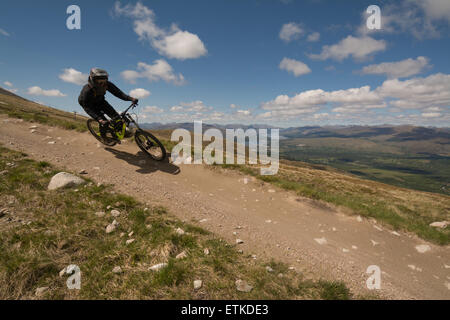 Nevis Range, Aonach Mor, Fort William, Scotland, UK: 14 June 2015. UK weather.  Downhill mountain biker making the most of a beautiful sunny day in the Scottish Highlands riding the 2.82km orange extreme track that was used last weekend for the second round of the UCI Mountain Bike World Cup Credit:  Kay Roxby/Alamy Live News Stock Photo