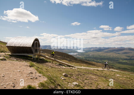 Nevis Range, Aonach Mor, Fort William, Scotland, UK: 14 June 2015. UK weather.  Downhill mountain bikers making the most of a beautiful sunny day in the Scottish Highlands as they set off down the 2.82km orange extreme track that was used last weekend for the second round of the UCI Mountain Bike World Cup Round 2 Credit:  Kay Roxby/Alamy Live News Stock Photo