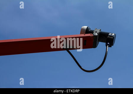 A satellite dish arm and LNB against a blue sky Stock Photo