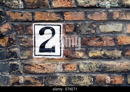 House number painted on brick wall Stock Photo