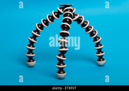 Close up view of a gorilla pod type tripod isolated on a blue background. Stock Photo