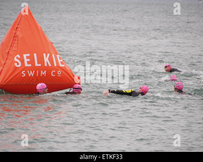 Swimmers taking part in a Triathon swim around an inflatable buoy Stock Photo