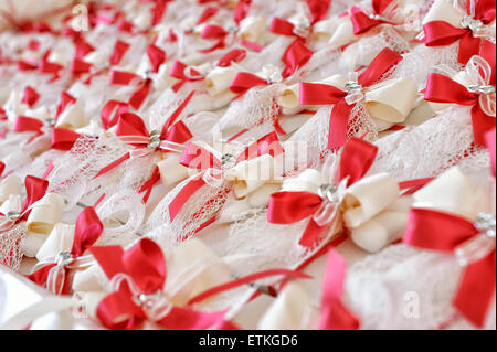 Close up Plenty of Attractive Party Favors for Guests with Red and White Ribbon Designs, Placed on Top of the Table Stock Photo