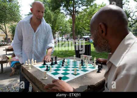 Men playing chess in public park table - DuPont Circle, Washington, DC USA Stock Photo