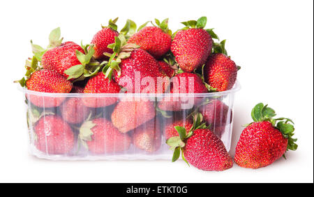 Freshly strawberries in a plastic tray and two near isolated on white background Stock Photo