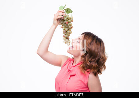 Young cute woman eating grapes isolated on a white background Stock Photo