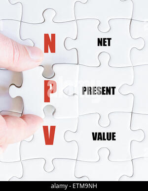 Hand of a business man completing the puzzle with the last missing piece.Concept image of Business Acronym NPV as Net Present Value Stock Photo