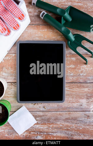 close up of tablet pc and garden tools on table Stock Photo