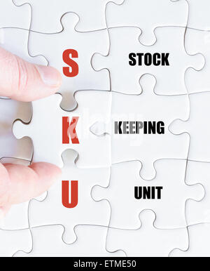 Hand of a business man completing the puzzle with the last missing piece.Concept image of Business Acronym SKU as Stock Keeping Unit Stock Photo