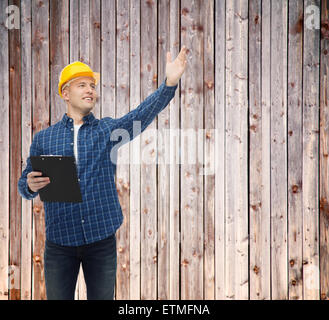 smiling male builder in helmet with clipboard Stock Photo