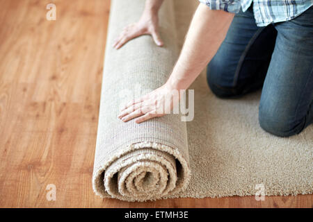 close up of male hands rolling carpet Stock Photo