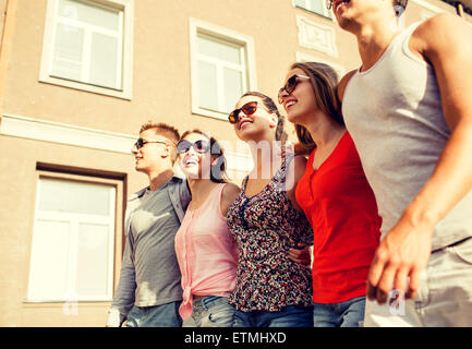 group of smiling friends walking in city Stock Photo