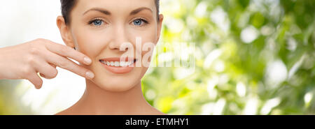 face and hand of smiling woman over green tarure Stock Photo