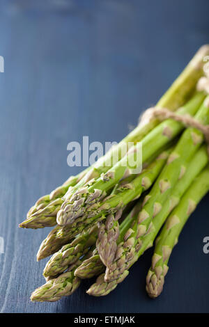 bunch of fresh asparagus on blue background Stock Photo